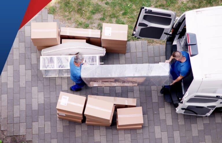 Pakettiauto, josta muuttomiehet kantavat tavaroita.